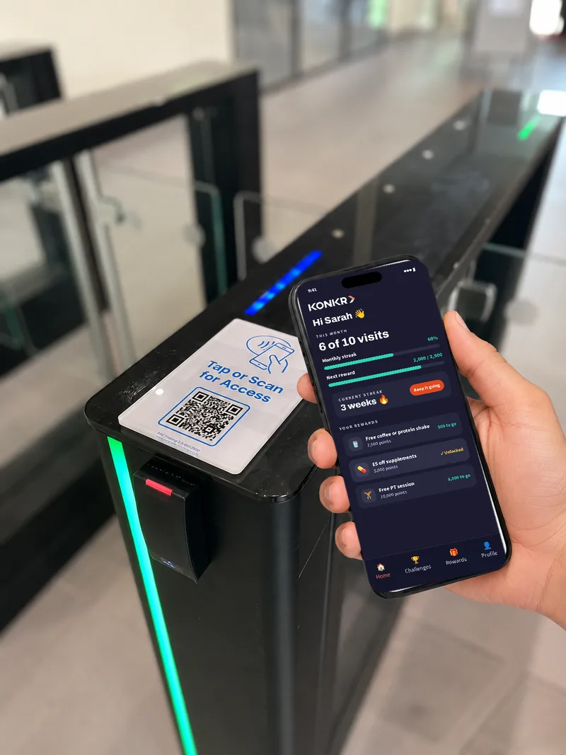 A member taps in at an access gate, with the Konkr app open showing their monthly visits, streak and a live challenge